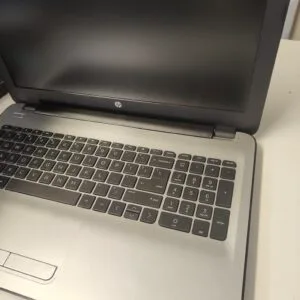 Open HP laptop on a light surface, showing the keyboard and bottom of the screen with the HP logo visible.