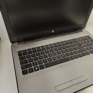 Open HP laptop with black keyboard and a blank laptop screen, angled on a light surface.