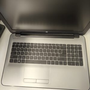 Top-down view of an HP laptop with the screen off and the keyboard fully visible on a light surface.
