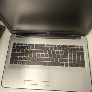 Top-down view of an HP laptop with the screen off and the keyboard fully visible on a light surface.